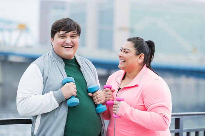 Fat girl and boy doing exercise